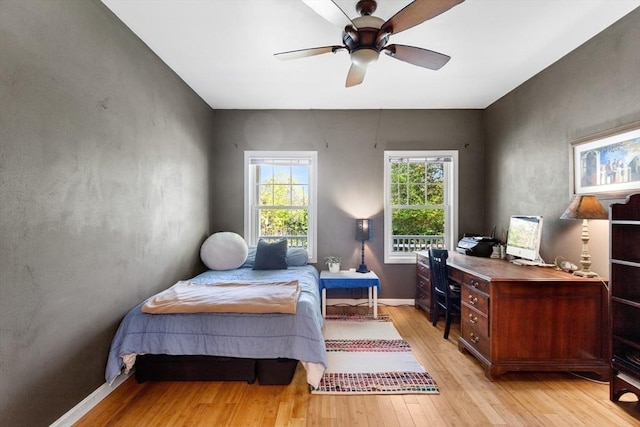 bedroom featuring light wood-style floors, a desk, and ceiling fan