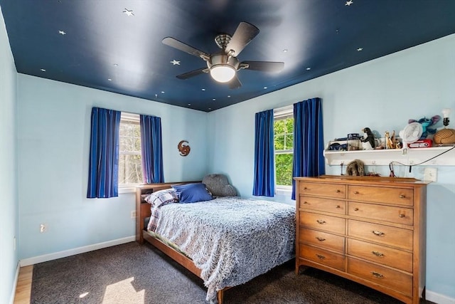 bedroom with baseboards, dark carpet, and ceiling fan