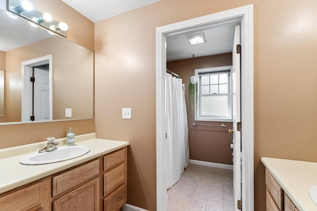 full bathroom featuring vanity, tile patterned floors, and baseboards