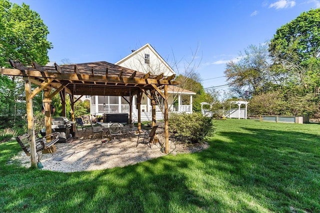 back of property featuring a pergola, a yard, a hot tub, and a patio area