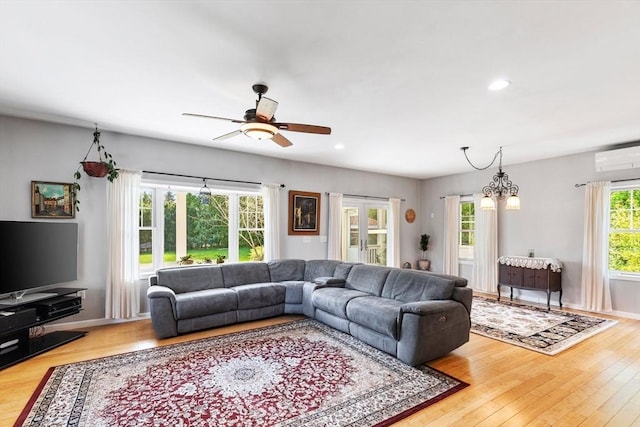 living room featuring light wood-style flooring, a ceiling fan, recessed lighting, a wall mounted air conditioner, and baseboards