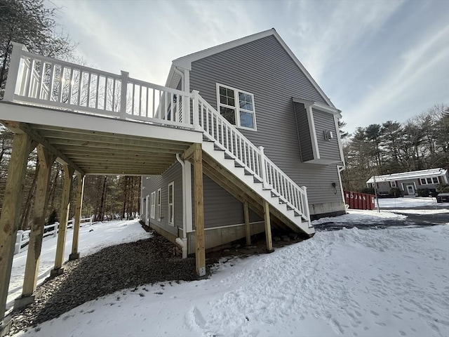 view of snowy exterior with a wooden deck