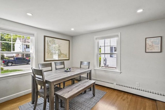 dining space featuring a baseboard radiator, wood finished floors, recessed lighting, and baseboards