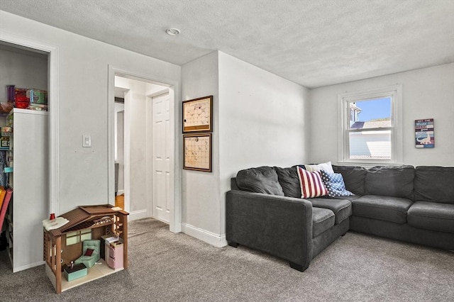 living room featuring carpet floors, baseboards, and a textured ceiling