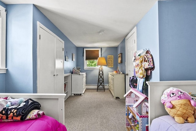 carpeted bedroom featuring a baseboard heating unit and baseboards