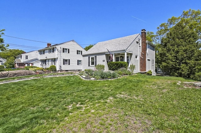 view of front of home with a chimney and a front lawn