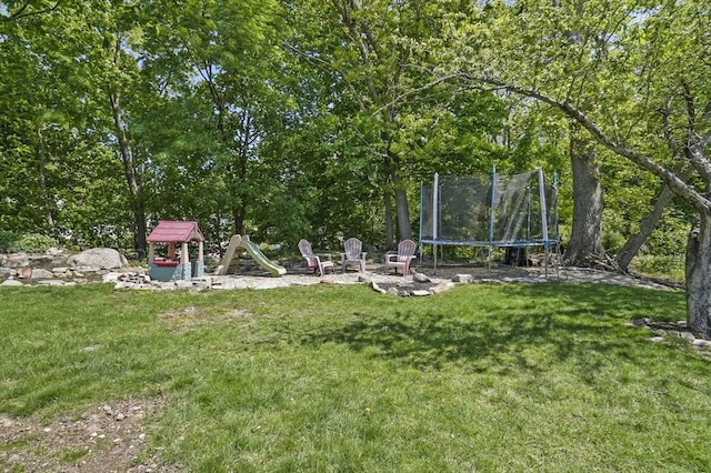 view of grassy yard with a trampoline