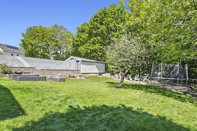 view of grassy yard featuring a trampoline