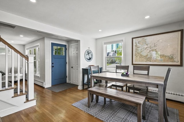 dining room with stairway, wood finished floors, recessed lighting, baseboard heating, and baseboards