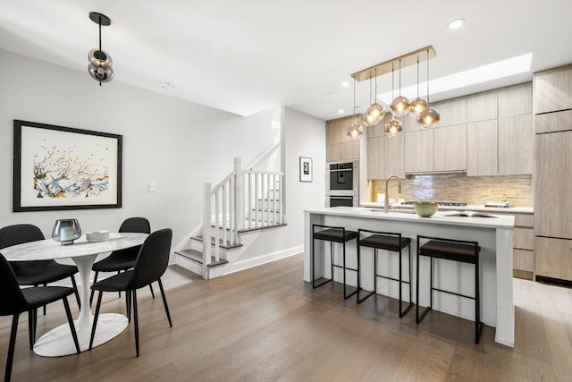 dining room featuring stairs, recessed lighting, light wood-style floors, and baseboards