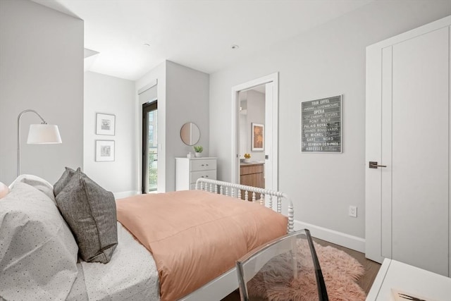 bedroom with ensuite bath and baseboards