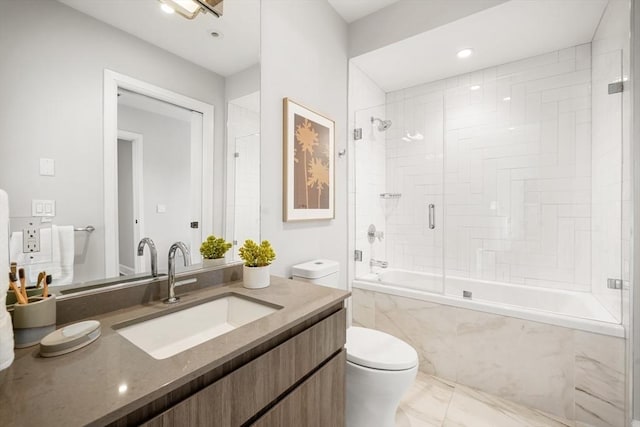 full bath featuring vanity, toilet, and a combined bath / shower with marble appearance