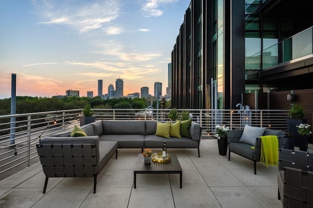 patio terrace at dusk with an outdoor living space and a view of city