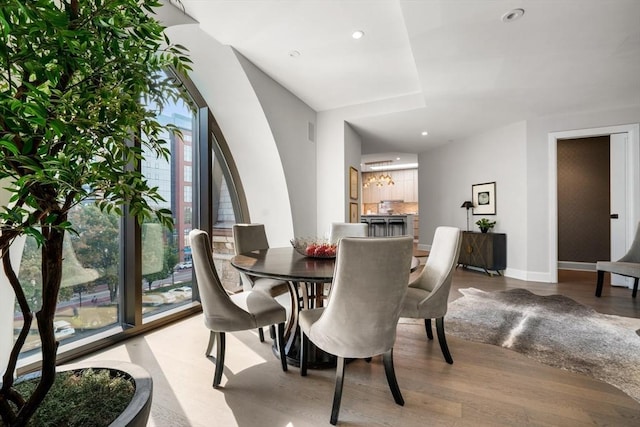 dining room featuring wood finished floors, recessed lighting, and baseboards