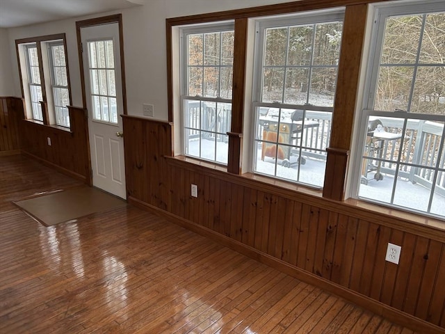 doorway to outside with wood walls and hardwood / wood-style floors