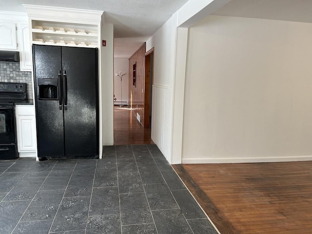 kitchen featuring decorative backsplash, ventilation hood, white cabinetry, and black appliances