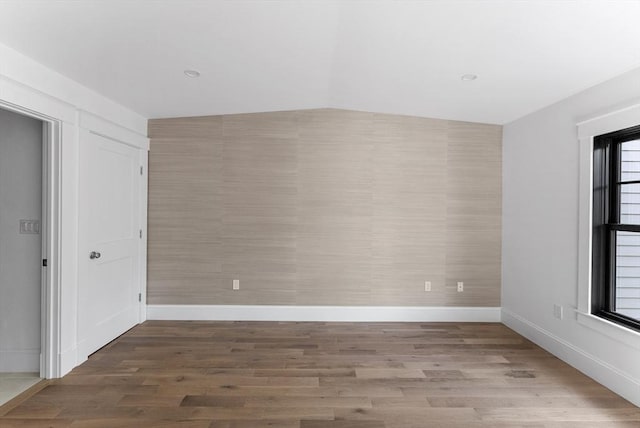 empty room featuring lofted ceiling and wood-type flooring