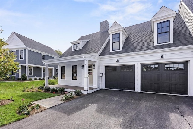 view of front facade featuring a garage, covered porch, and a front lawn