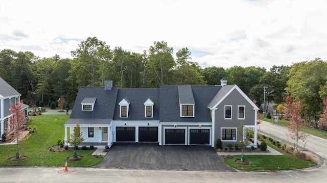 cape cod-style house featuring a front yard and a garage