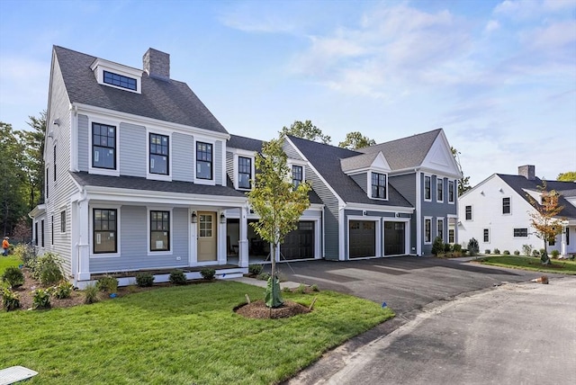 view of front of house with a porch, a front yard, and a garage