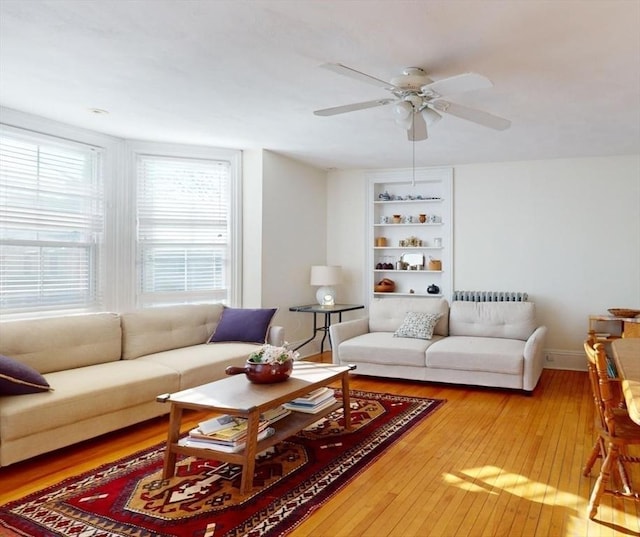 living room featuring ceiling fan and hardwood / wood-style flooring