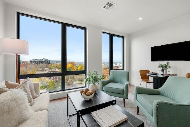 living area featuring visible vents, baseboards, and wood finished floors