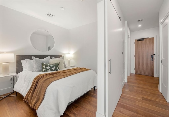 bedroom with visible vents and wood finished floors