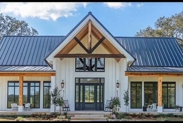 view of exterior entry featuring french doors, a standing seam roof, and metal roof