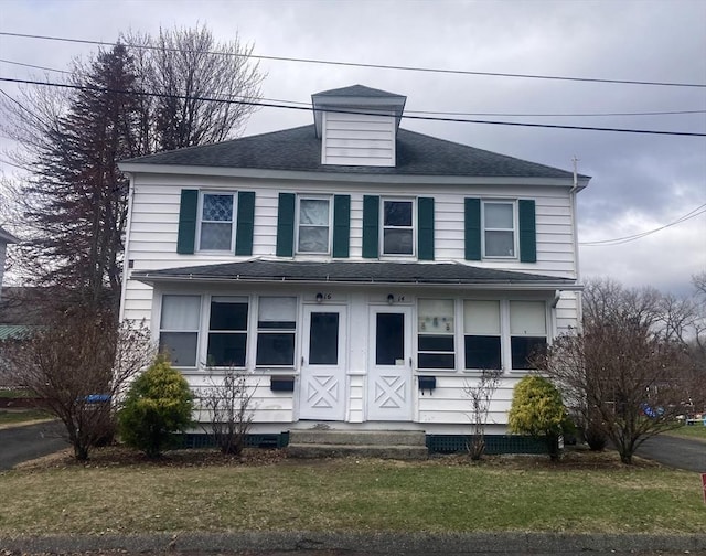 view of front of house with a front yard, roof with shingles, and entry steps