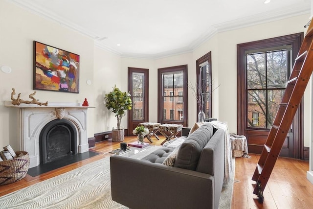 living area featuring a fireplace with flush hearth, recessed lighting, ornamental molding, and light wood finished floors