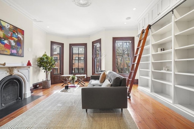 sitting room featuring a fireplace with flush hearth, recessed lighting, light wood-style floors, and ornamental molding