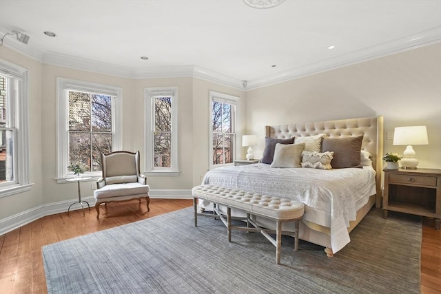 bedroom featuring baseboards, wood finished floors, and crown molding