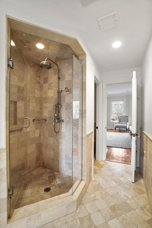 full bathroom with a stall shower, wainscoting, and visible vents