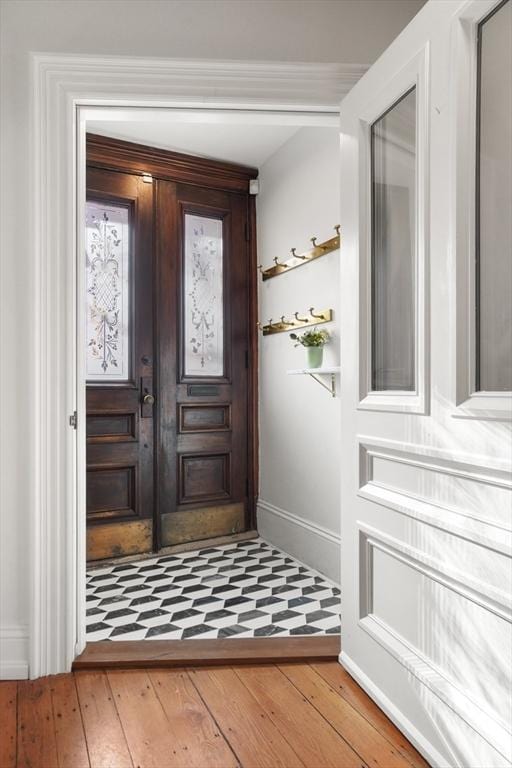 entrance foyer featuring baseboards, french doors, and light wood-style floors