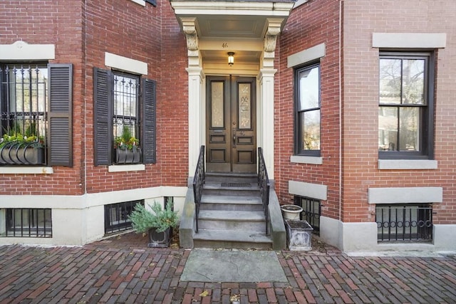 doorway to property featuring brick siding