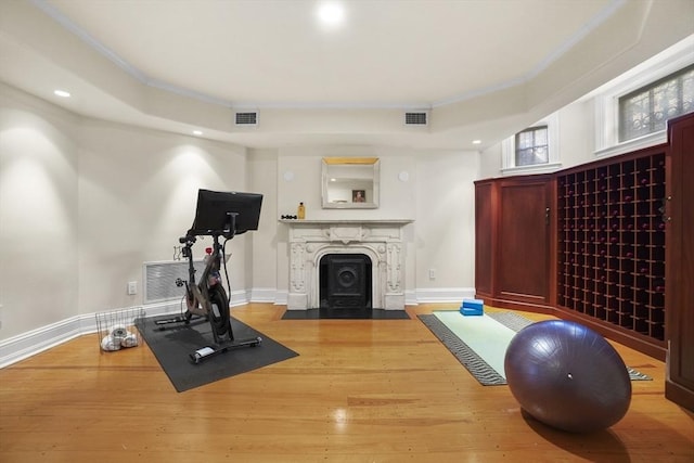 workout room featuring visible vents, baseboards, and wood finished floors