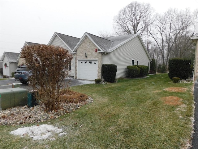 view of side of property featuring a garage and a lawn