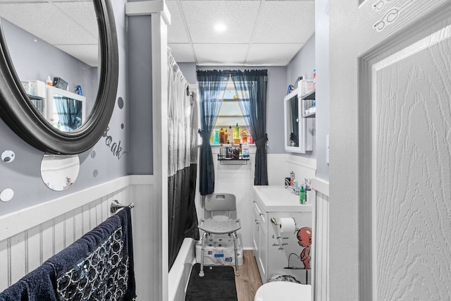 full bathroom featuring toilet, hardwood / wood-style floors, a paneled ceiling, vanity, and shower / bath combination with curtain