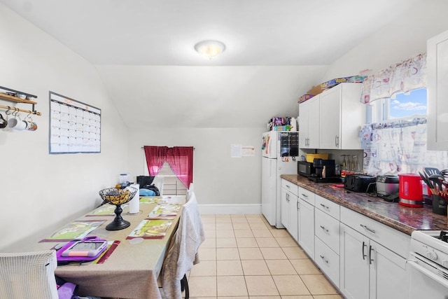 kitchen with light tile patterned flooring, white appliances, white cabinetry, and vaulted ceiling