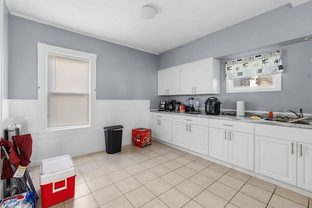 kitchen featuring white cabinets, light tile patterned floors, and sink