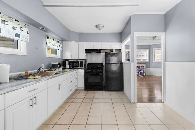 kitchen featuring black appliances, white cabinetry, sink, and light stone countertops