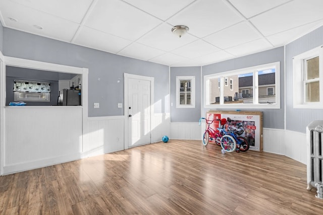 misc room featuring a wealth of natural light, a drop ceiling, and hardwood / wood-style flooring