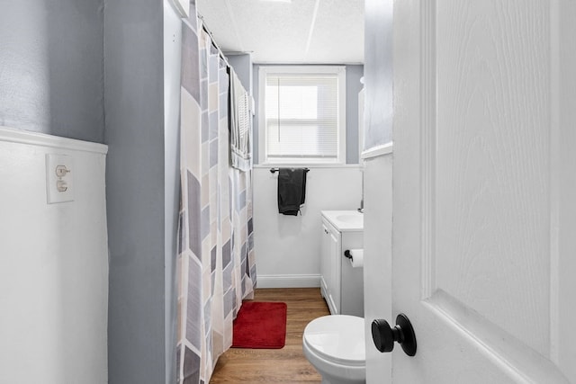 bathroom featuring toilet, a shower with curtain, and wood-type flooring