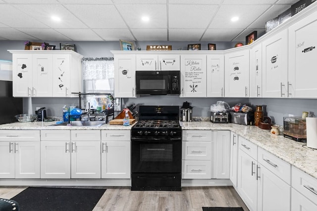 kitchen with white cabinets, black appliances, and sink