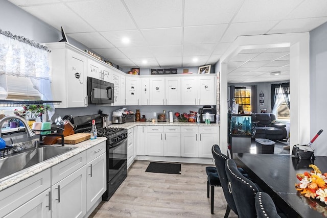 kitchen with black appliances and white cabinetry