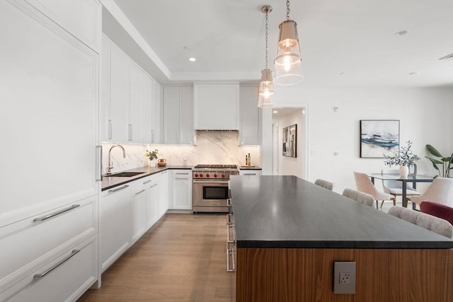 kitchen featuring a sink, dark countertops, a center island, and high end stainless steel range