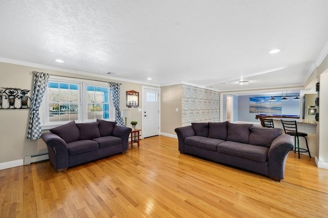 living room with baseboard heating, ornamental molding, and light wood-type flooring