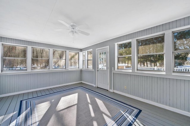 unfurnished sunroom featuring ceiling fan