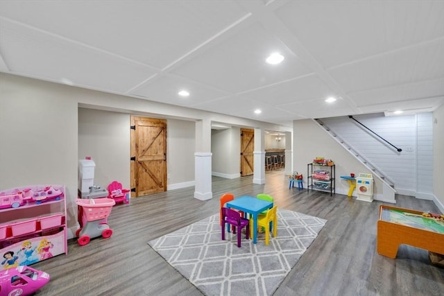 rec room featuring a barn door and hardwood / wood-style floors