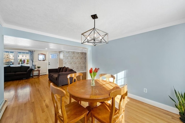 dining room featuring crown molding, a notable chandelier, light wood-type flooring, and baseboard heating